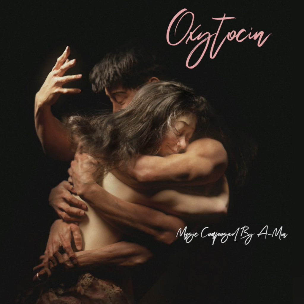 Pochette de l'album Oxytocin composée par A-MIN. Photographie de style clair-obscur montrant un homme et une femme dans une étreinte passionnée et fusionnelle sur fond noir. Le titre OxyTocin est écrit en rose.